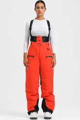Pantalones de nieve holgados con aislamiento en rojo neón para mujer con tirantes desmontables
